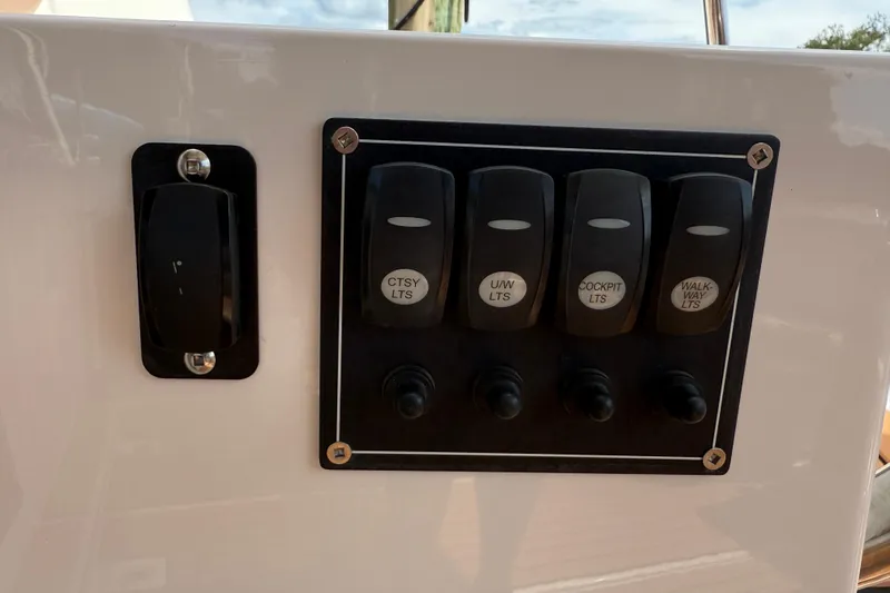 Slide: The Image of Control panel of 2021 Ranger Tugs R-41CB with labeled light switches. - 14