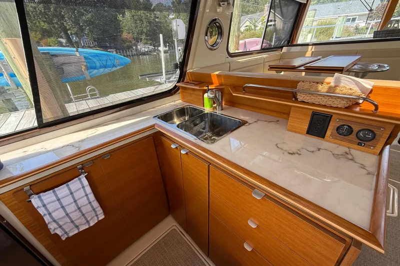Slide: The Image of 2021 Ranger Tugs R-41CB boat interior with modern kitchen and marble countertop. - 18