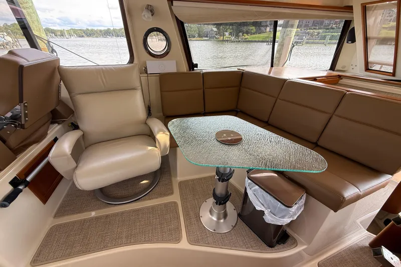 Slide: The Image of Interior of 2021 Ranger Tugs R-41CB with leather seating and glass table, overlooking water. - 24