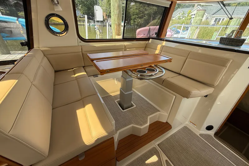 Slide: The Image of Interior of 2021 Ranger Tugs R-41CB with beige seating and wooden table. - 25