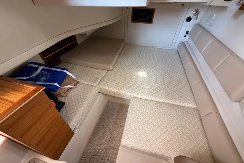 Slide: The Image of 2021 Ranger Tugs R-41CB cabin interior with beige seating and storage. - 35