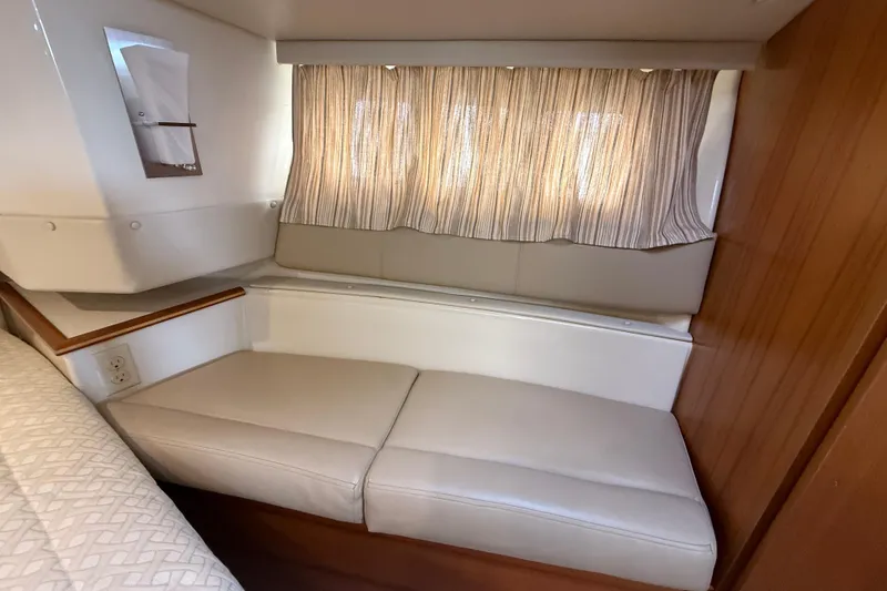 Slide: The Image of 2021 Ranger Tugs R-41CB interior cabin with cushioned seating and striped curtains. - 40