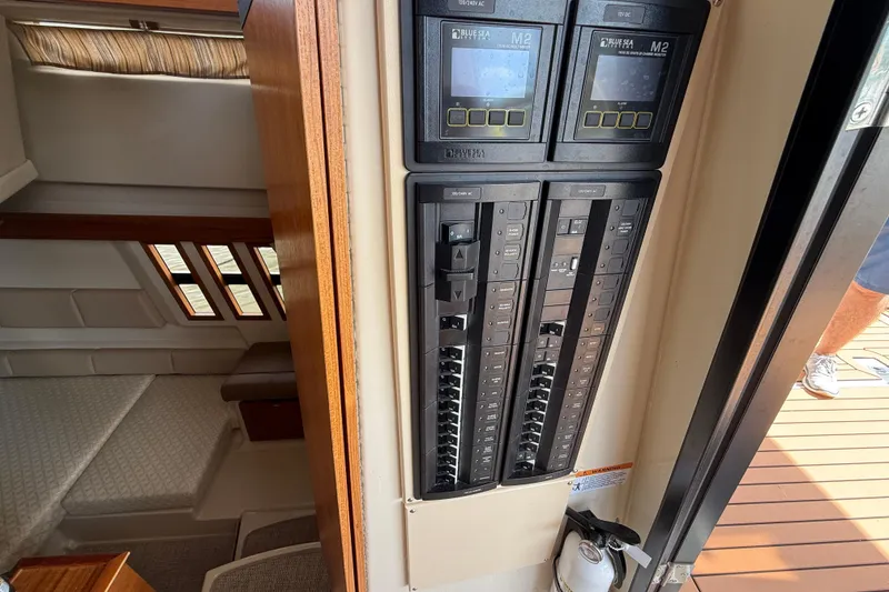 Slide: The Image of Electrical panel inside 2021 Ranger Tugs R-41CB boat, showing control switches and cabin interior. - 65