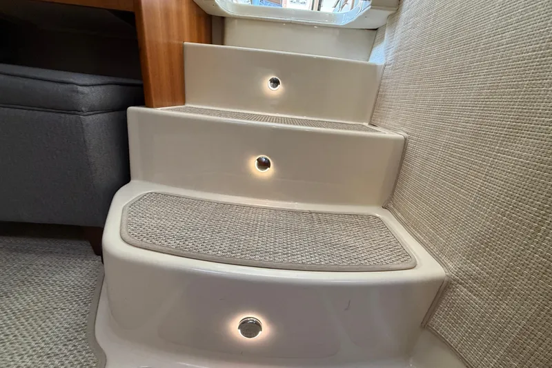 Slide: The Image of Illuminated interior steps on 2021 Ranger Tugs R-41CB boat, featuring carpeted treads. - 68