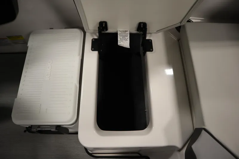 Slide: The Image of 2026 Yamaha Boats AR220 storage compartment with Igloo cooler, open lid view. - 37