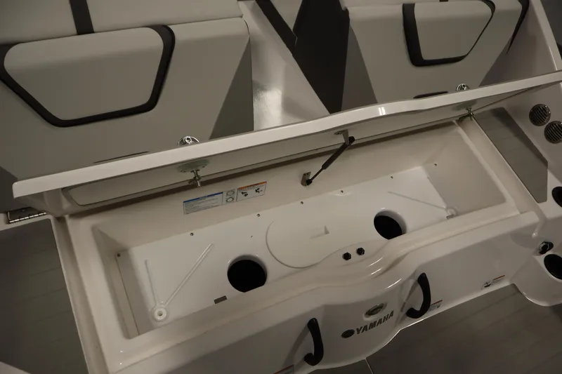Slide: The Image of 2026 Yamaha Boats AR220 storage compartment with open lid, showcasing interior design. - 40