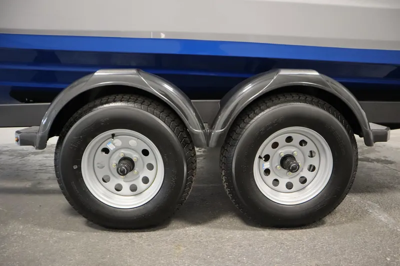 Slide: The Image of Trailer wheels of a 2026 Yamaha Boats AR220, featuring dual axles and sturdy tires. - 45