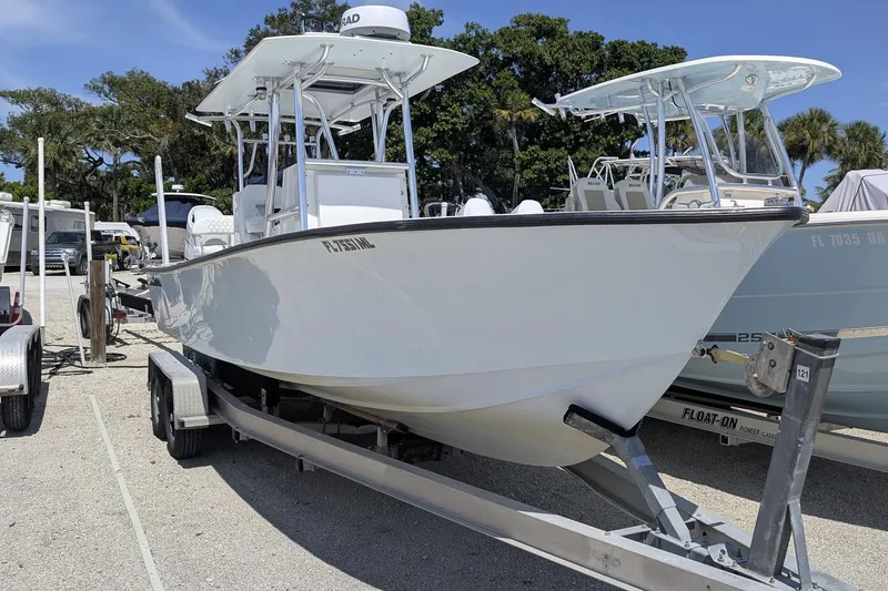 The Image of 1985 Contender 25 Sport boat docked in a serene waterfront setting. - 0