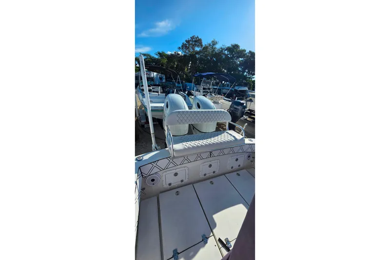 Slide: The Image of 1985 Contender 25 Sport boat with dual engines, docked under clear blue sky. - 18