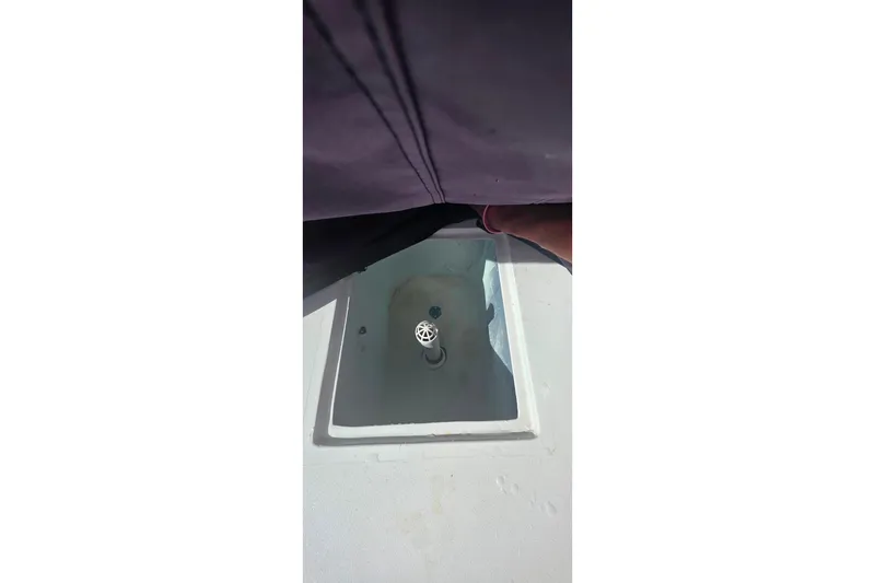 Slide: The Image of Contender 25 Sport 1985 boat interior with open hatch and visible drain. - 19