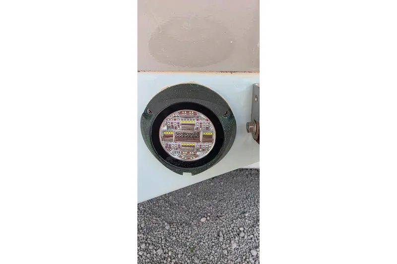 Slide: The Image of LED light on 1985 Contender 25 Sport boat hull, gravel background. - 20