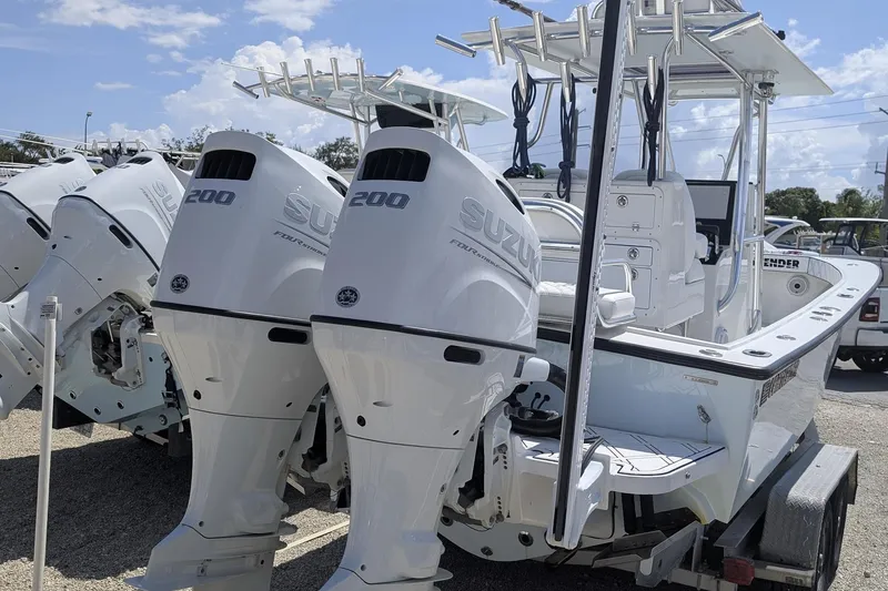 Slide: The Image of 1985 Contender 25 Sport boat with dual Suzuki 200 engines, parked under a cloudy sky. - 4