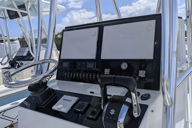 Slide: The Image of 1985 Contender 25 Sport boat interior with Suzuki engine, featuring white seating and storage compartments. - 6