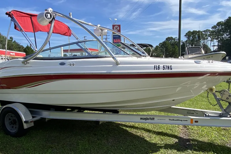 The Image of 2006 Chaparral 190 SSi boat with red canopy on trailer, parked outdoors. - 1