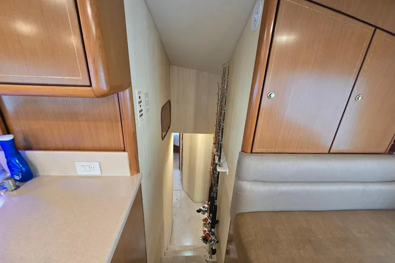 Slide: The Image of 2004 Ocean Yachts 50 Super Sport interior with wooden cabinets and fishing rods. - 17