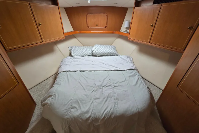 Slide: The Image of Cozy bedroom in 2004 Ocean Yachts 50 Super Sport with wooden cabinets and comfortable bedding. - 21