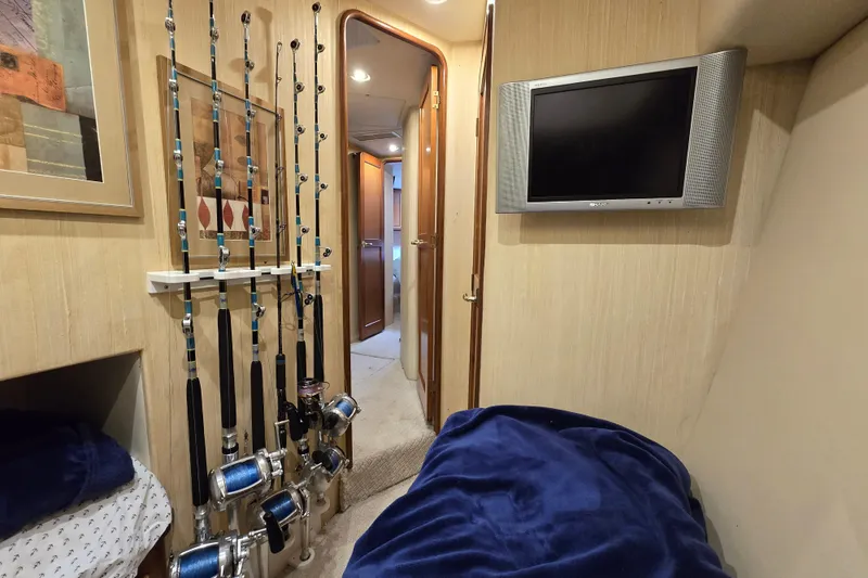 Slide: The Image of 2004 Ocean Yachts 50 Super Sport cabin with fishing rods and wall-mounted TV. - 26