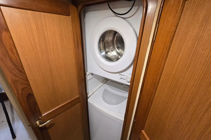 Slide: The Image of Laundry area with washer and dryer inside 2004 Ocean Yachts 50 Super Sport. - 27