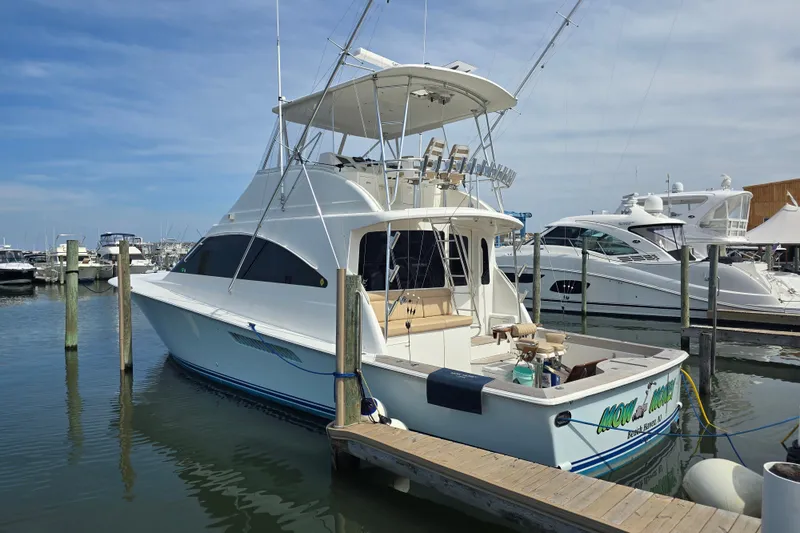 Slide: The Image of 2004 Ocean Yachts 50 Super Sport docked at marina, clear sky background. - 4