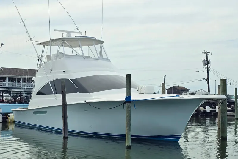 Slide: The Image of 2004 Ocean Yachts 50 Super Sport docked at a marina, showcasing sleek design and fishing equipment. - 8