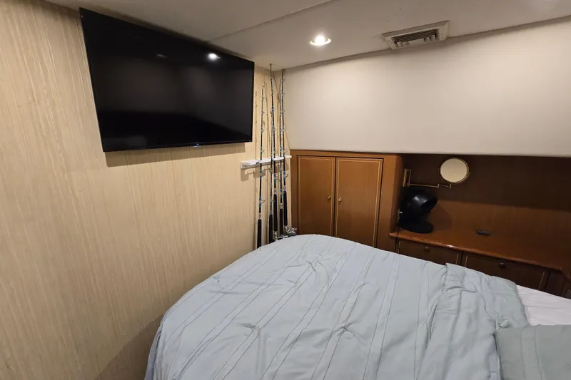 Slide: The Image of Interior of 2004 Ocean Yachts 50 Super Sport with TV, bed, and fishing rods. - 19