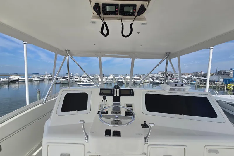 Slide: The Image of Helm of 2004 Ocean Yachts 50 Super Sport overlooking marina with docked boats. - 34