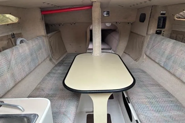 Slide: The Image of Interior of 1991 Corsair F-27 #227 sailboat, featuring a cozy dining area with cushioned seating. - 10