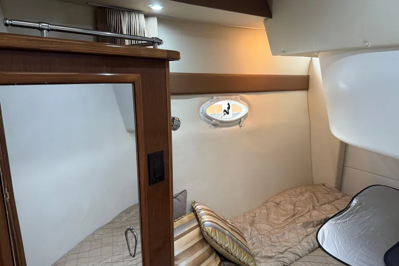 Slide: The Image of Interior cabin of 2007 Carver 35 Super Sport yacht, featuring cozy bedding and porthole. - 17