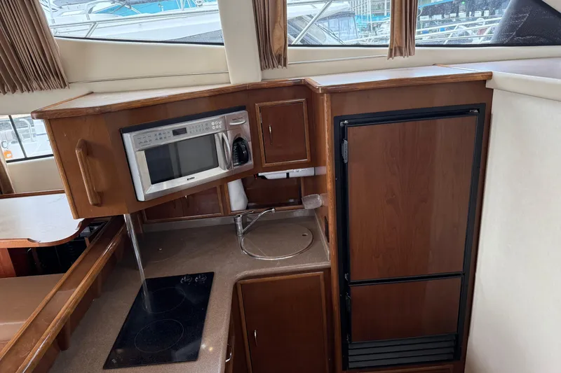 Slide: The Image of 2007 Carver 35 Super Sport yacht kitchen with microwave, stove, and fridge. - 13