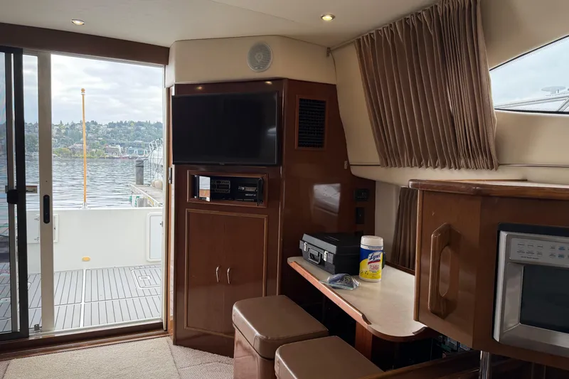 Slide: The Image of Interior of 2007 Carver 35 Super Sport yacht with TV, table, and lake view. - 14
