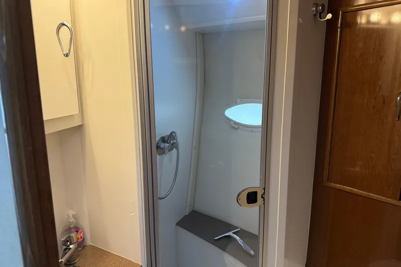 Slide: The Image of Shower area in 2007 Carver 35 Super Sport yacht, featuring modern fixtures and porthole. - 18