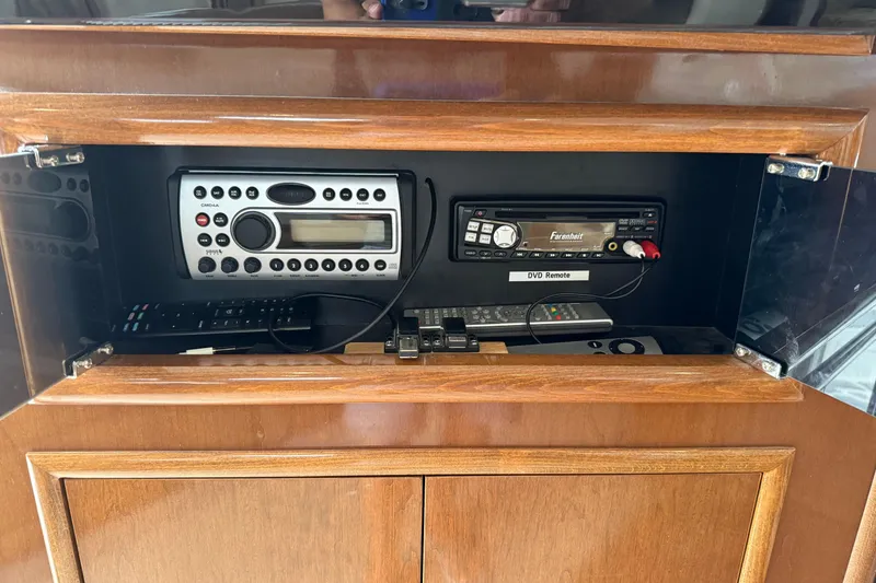 Slide: The Image of 2007 Carver 35 Super Sport audio system with remote controls in wooden cabinet. - 20