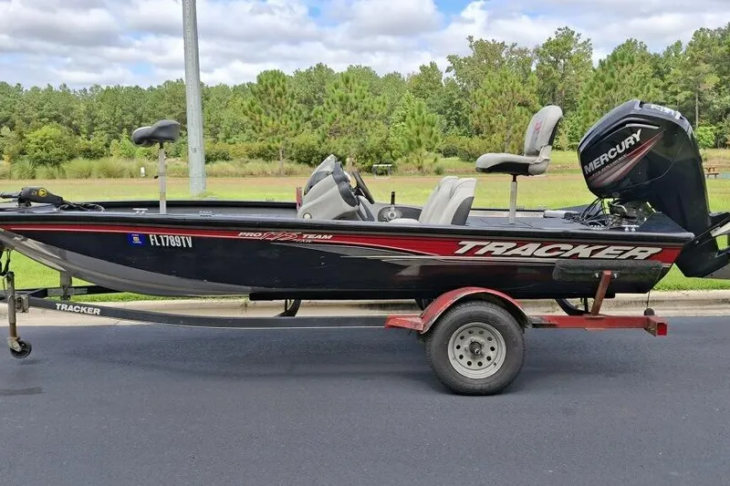 The Image of 2017 Tracker Pro Team 175 TX boat on trailer with Mercury engine, parked outdoors. - 1