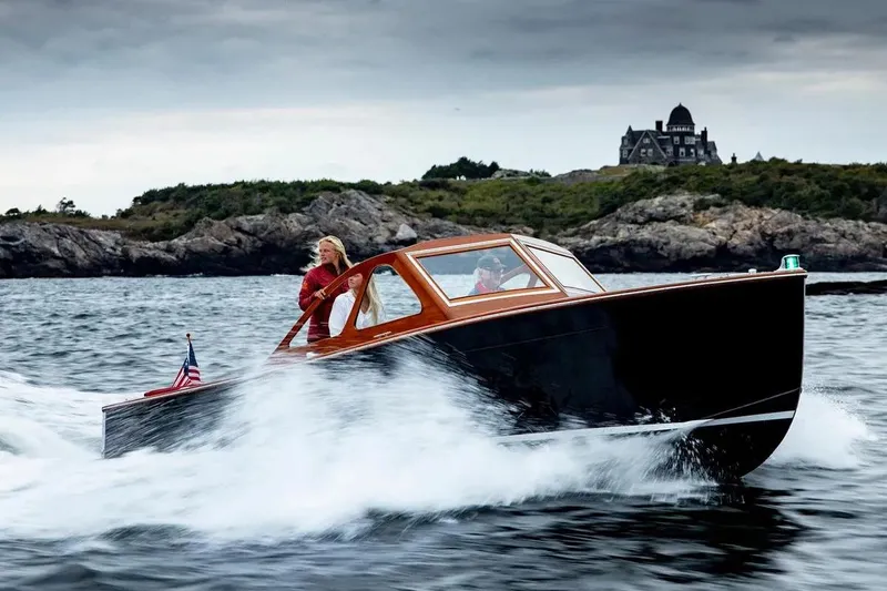 Slide: The Image of 1959 Forest E Johnson Prowler boat cruising near rocky coastline with distant mansion. - 3