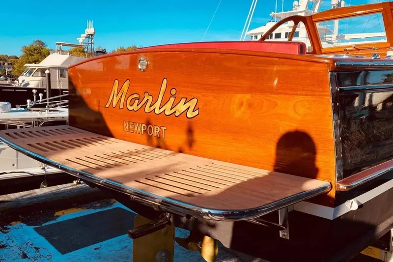 Slide: The Image of 1959 Forest E Johnson Prowler boat, "Marlin Newport," with polished wood finish at marina. - 8