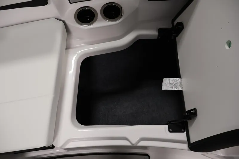 Slide: The Image of Open storage compartment in 2026 Yamaha Boats 222S, featuring cup holders and sleek design. - 14