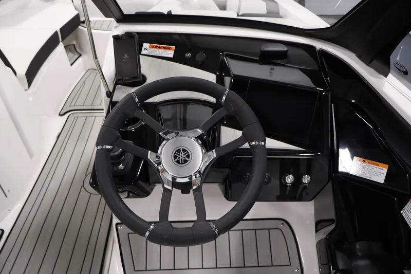 Slide: The Image of Steering wheel and dashboard of 2026 Yamaha Boats 222S, featuring sleek design and controls. - 17