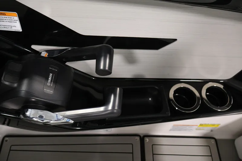 Slide: The Image of 2026 Yamaha Boats 222S throttle controls and cup holders in sleek black design. - 23