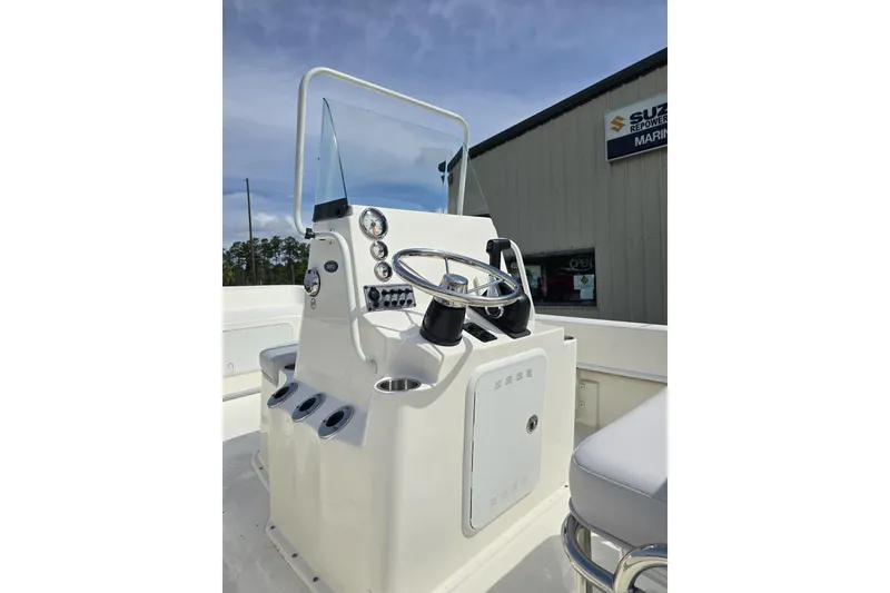 Slide: The Image of 2025 Sundance B20CCR boat console with steering wheel and gauges, outdoor marine setting. - 5
