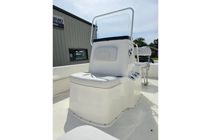 Slide: The Image of 2025 Sundance B20CCR boat console with seating, located outdoors near a marine center. - 6