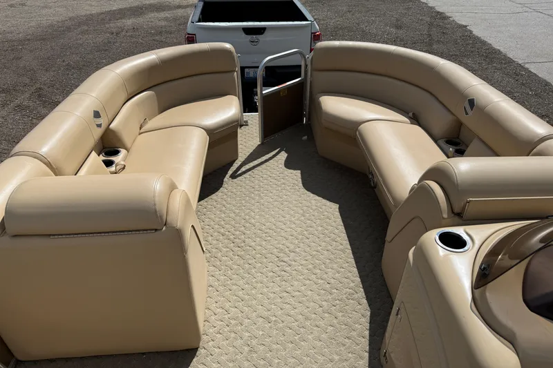 Slide: The Image of 2015 South Bay 522CR pontoon boat interior with beige seating and cup holders. - 6