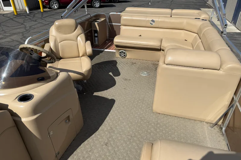 Slide: The Image of 2015 South Bay 522CR pontoon boat interior with beige seating and steering console. - 7
