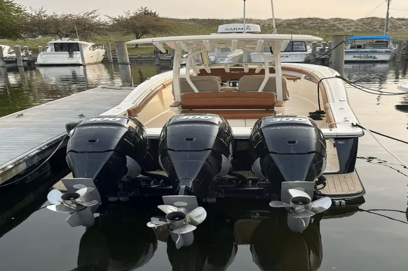 Slide: The Image of 2017 Scout 350 LXF boat with triple 300 horsepower engines docked at marina. - 2