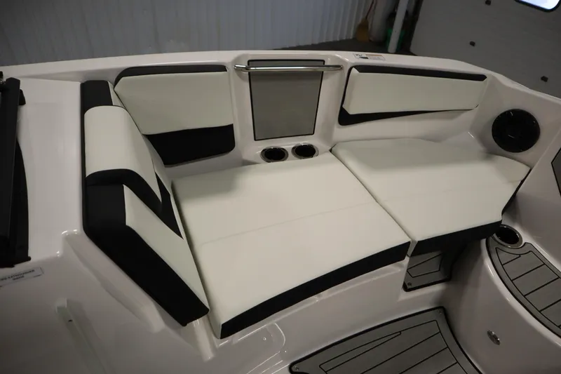 Slide: The Image of 2026 Yamaha Boats 222SD interior seating with sleek white and black upholstery, cup holders, and speaker. - 13