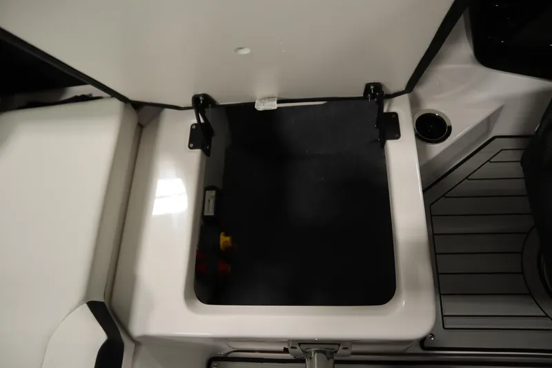 Slide: The Image of 2026 Yamaha Boats 222SD storage compartment with open lid, showcasing interior space and sleek design. - 35