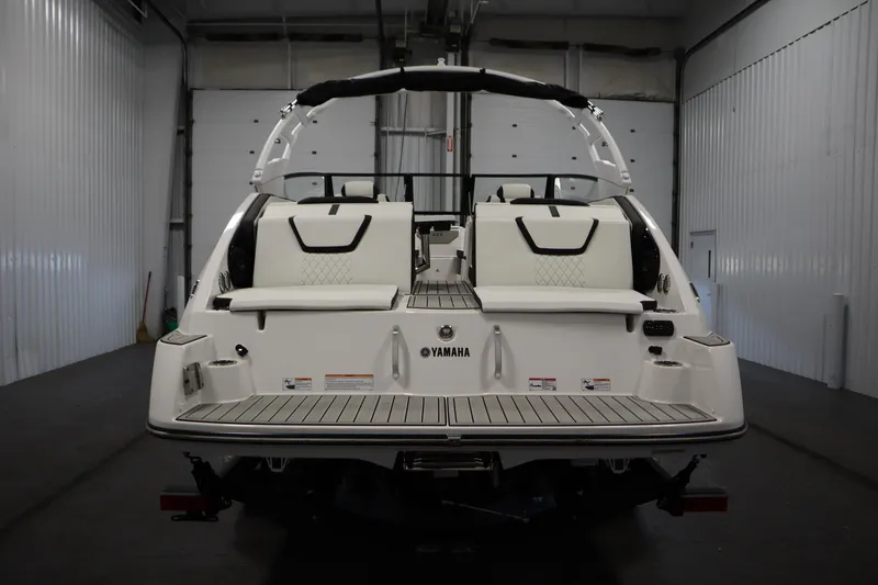 Slide: The Image of 2026 Yamaha Boats 222SD, rear view in a garage, showcasing sleek design and seating. - 5