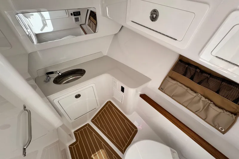 Slide: The Image of 2026 Southport 33 DC boat interior with sink, storage, and wooden flooring. - 17