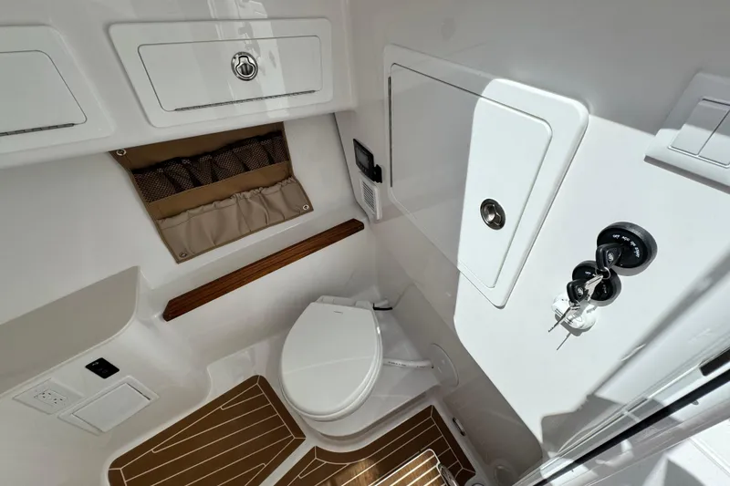 Slide: The Image of 2026 Southport 33 DC boat interior with toilet, storage, and wooden flooring. - 18