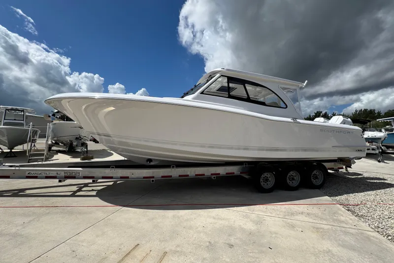 Slide: The Image of 2026 Southport 33 DC boat on trailer under cloudy sky. - 2