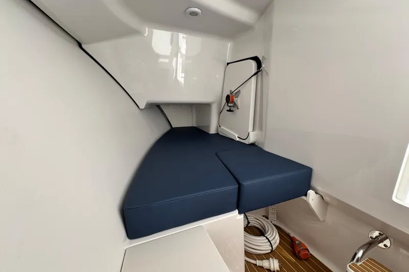 Slide: The Image of Interior cabin of 2026 Southport 33 DC boat with blue cushioned seating. - 23